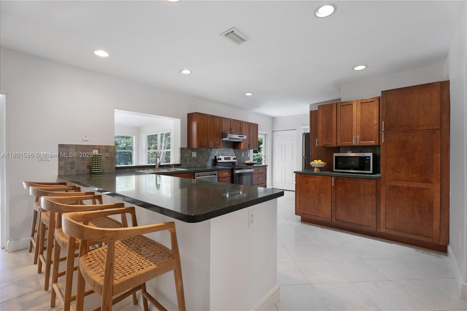 8700 Southwest 64th Avenue Pinecrest, FL 33156 - Photo 6 of 11 a kitchen with stainless steel appliances granite countertop a refrigerator a stove top oven a sink and dishwasher