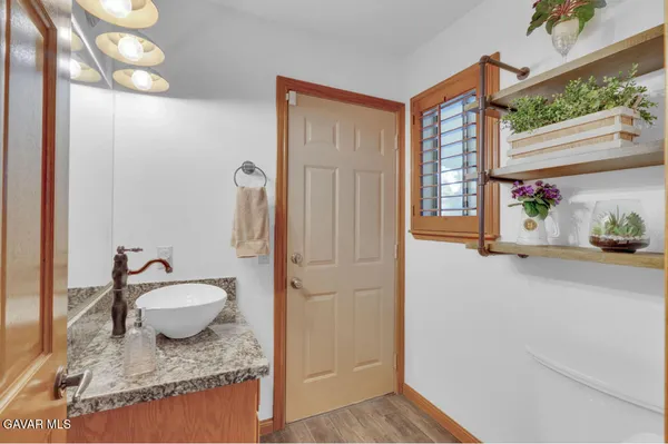 a bathroom with a granite countertop sink and a mirror
