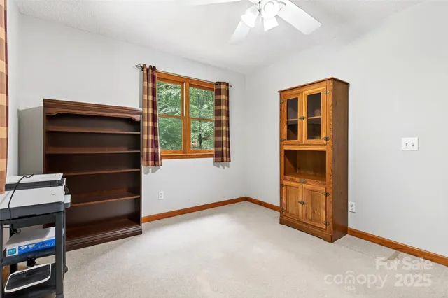 a bed sitting in a spacious bedroom next to a window