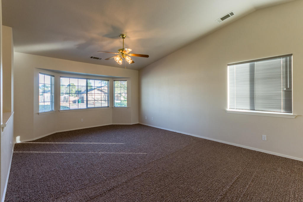 11380 Puffin Way Redding, CA 96003 - Photo 3 of 27 an empty room with windows and chandelier fan