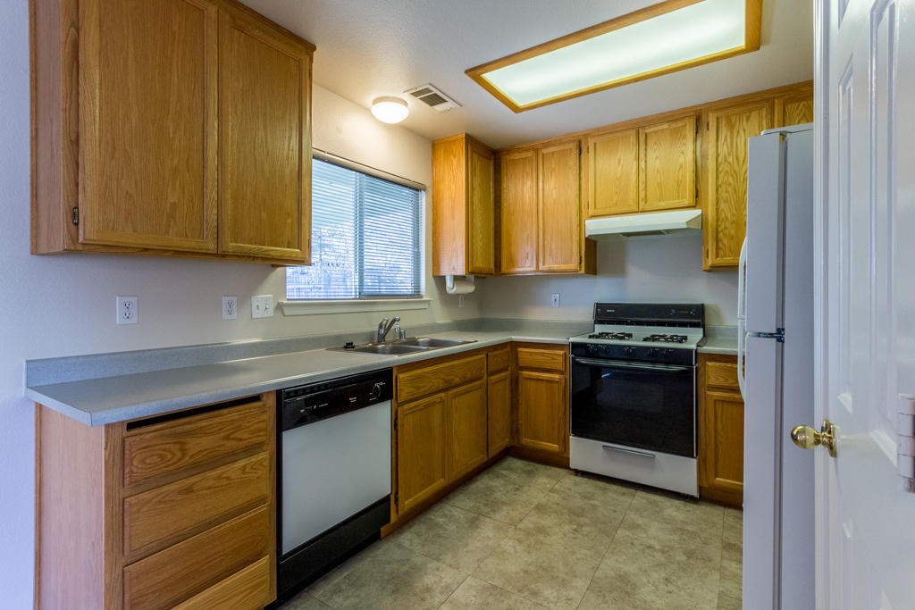 11380 Puffin Way Redding, CA 96003 - Photo 7 of 27 a kitchen with stainless steel appliances granite countertop wooden cabinets a stove top oven a sink and dishwasher