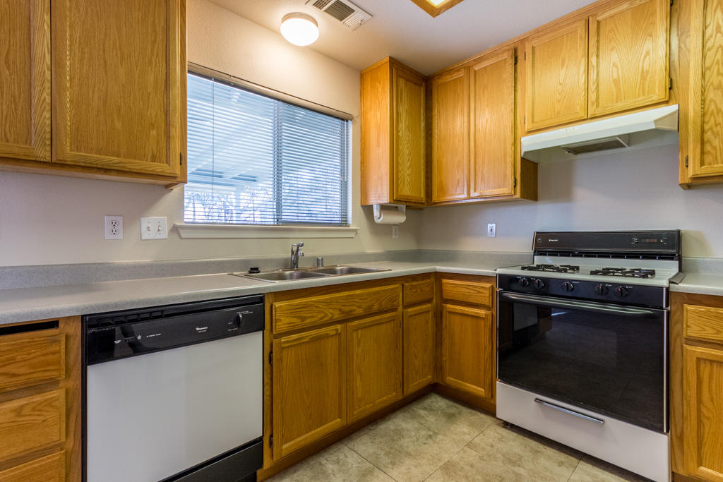 11380 Puffin Way Redding, CA 96003 - Photo 9 of 27 a kitchen with stainless steel appliances granite countertop wooden cabinets stove top oven and sink