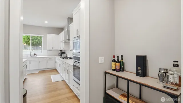 a kitchen with white cabinets and appliances