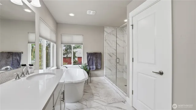 a large spacious bathroom with a tub sink shower and mirror