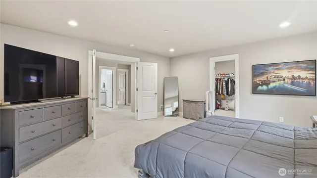 a spacious bedroom with a bed and a flat screen television