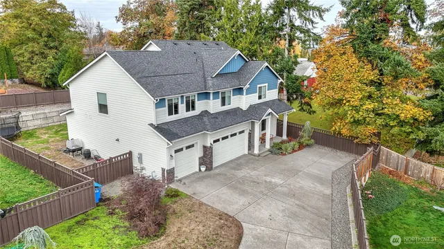 a house view with a garden and wooden fence
