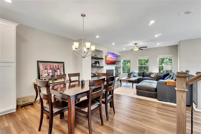 a kitchen with stainless steel appliances granite countertop a stove top oven a refrigerator a sink and chairs