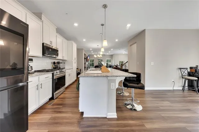 a kitchen with granite countertop white cabinets and appliances