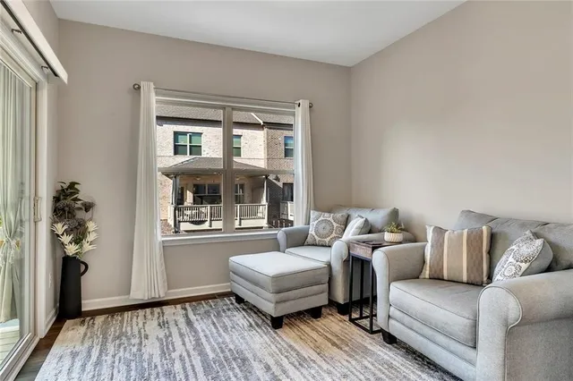 a large white kitchen with wooden floor and chairs