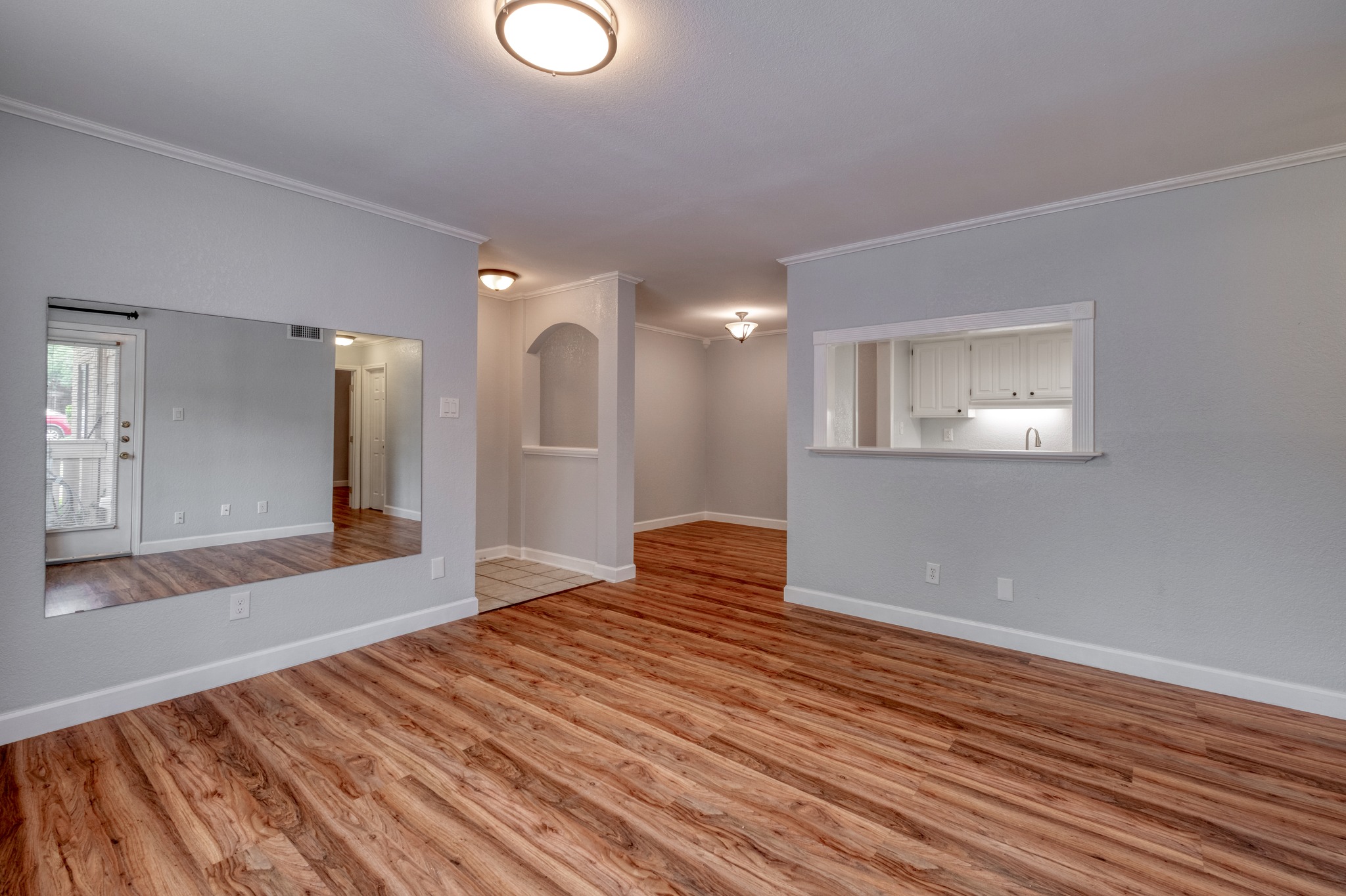 Spacious interior featuring wood-finish flooring, white baseboards, and light gray walls