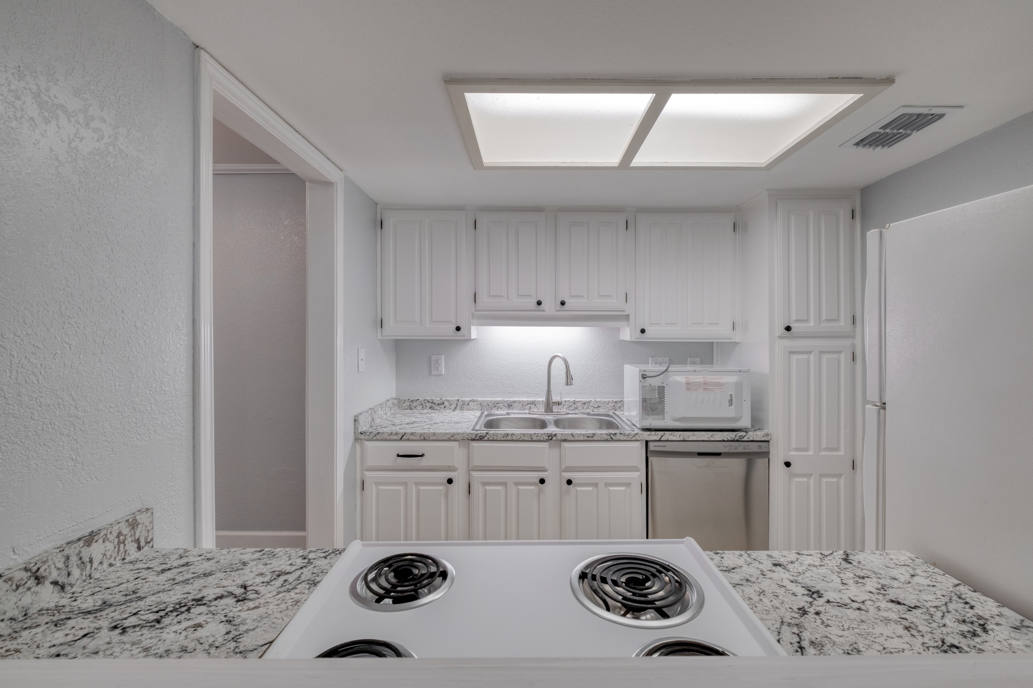 8210 Bent Tree Road, Unit 153 Austin, TX 78759 - Photo 15 of 20 Kitchen featuring white cabinetry, granite countertops, stainless steel sink, and recessed lighting