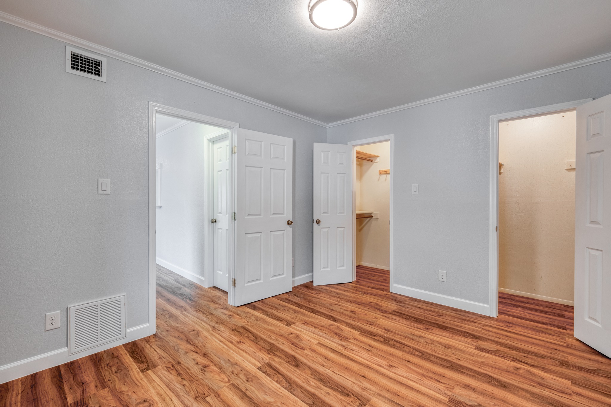 8210 Bent Tree Road, Unit 153 Austin, TX 78759 - Photo 18 of 20 Spacious room featuring wood-finish flooring, light gray walls, white trim, and crown molding