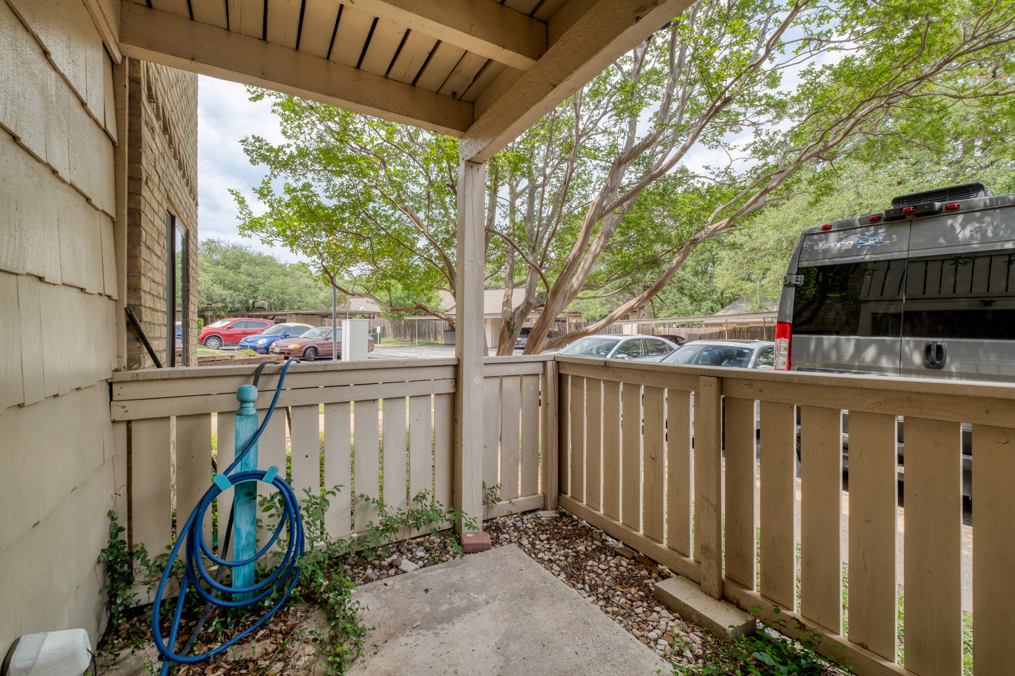 8210 Bent Tree Road, Unit 153 Austin, TX 78759 - Photo 20 of 20 Covered patio with a concrete slab, wood slat fencing, and a vertical wood support beam