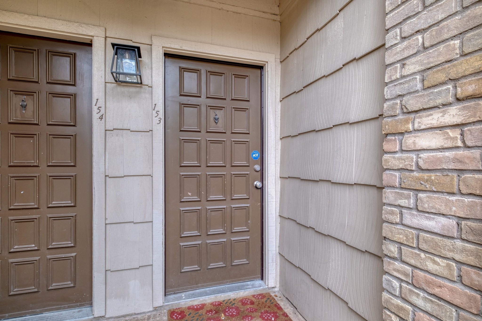 8210 Bent Tree Road, Unit 153 Austin, TX 78759 - Photo 2 of 20 Warm brown paneled entry door featuring a door knocker and a silver-tone doorknob