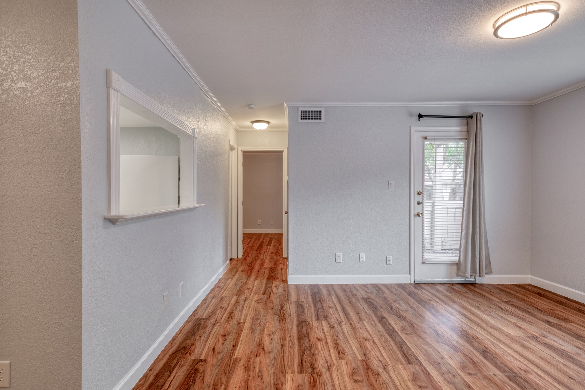 8210 Bent Tree Road, Unit 153 Austin, TX 78759 - Photo 6 of 20 Open living area featuring wood-finish flooring, light gray walls, and crown molding