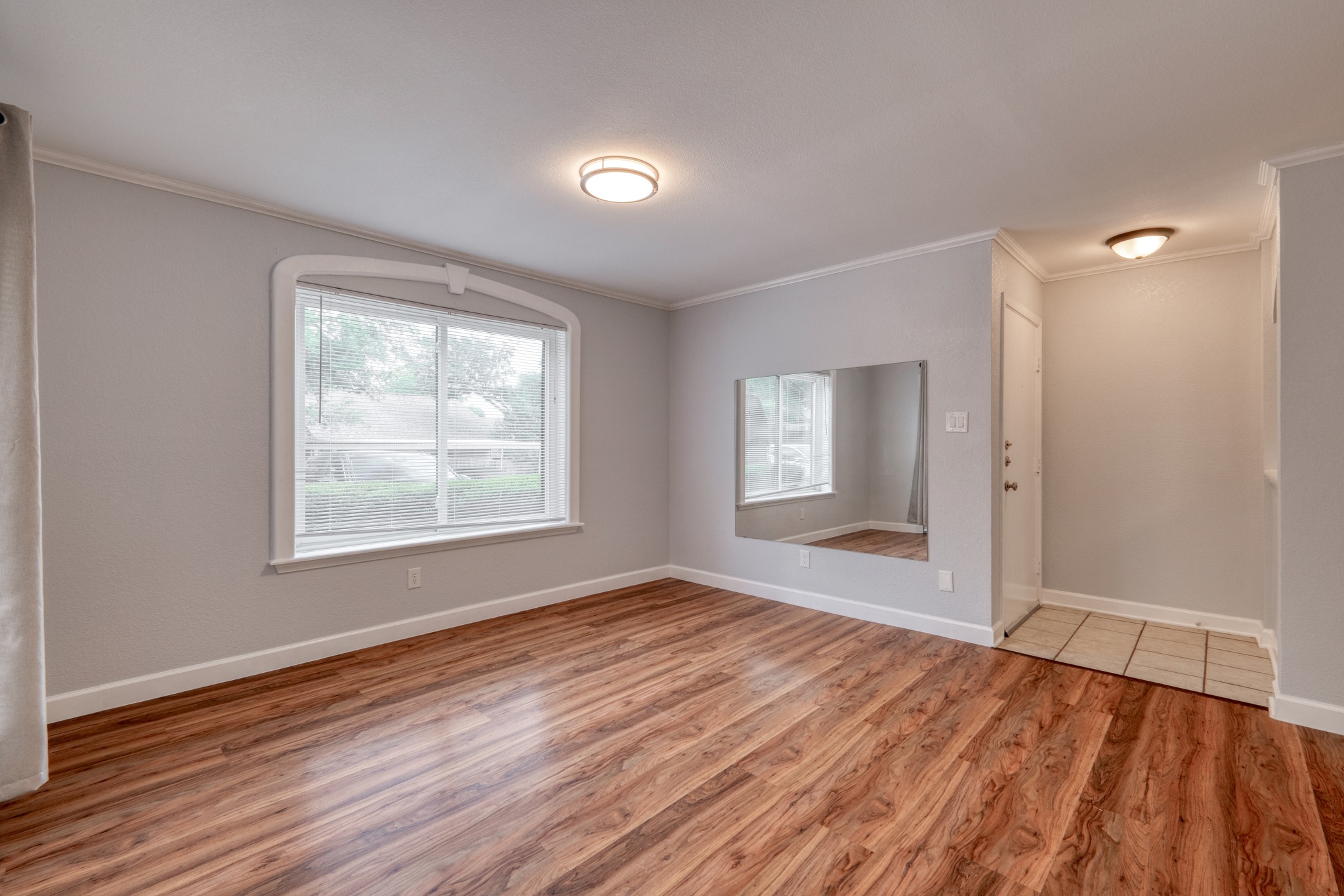 8210 Bent Tree Road, Unit 153 Austin, TX 78759 - Photo 8 of 20 Spacious room featuring wood-finish flooring, light gray walls, and crown molding