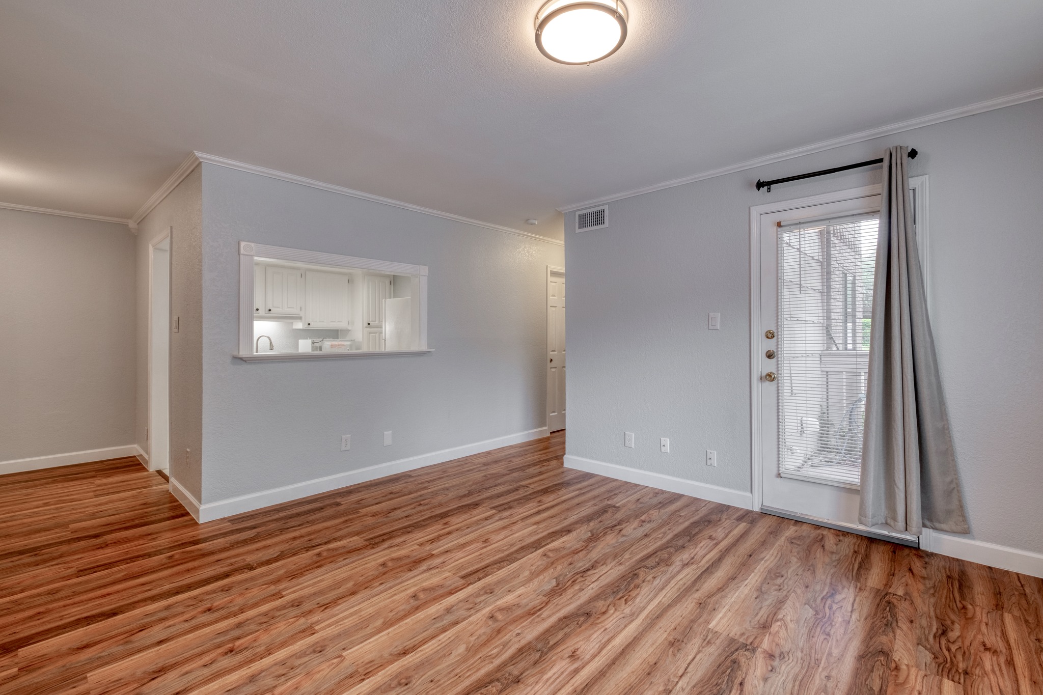 8210 Bent Tree Road, Unit 153 Austin, TX 78759 - Photo 9 of 20 Living area featuring wood-finish flooring, light gray wall paint, and white trim