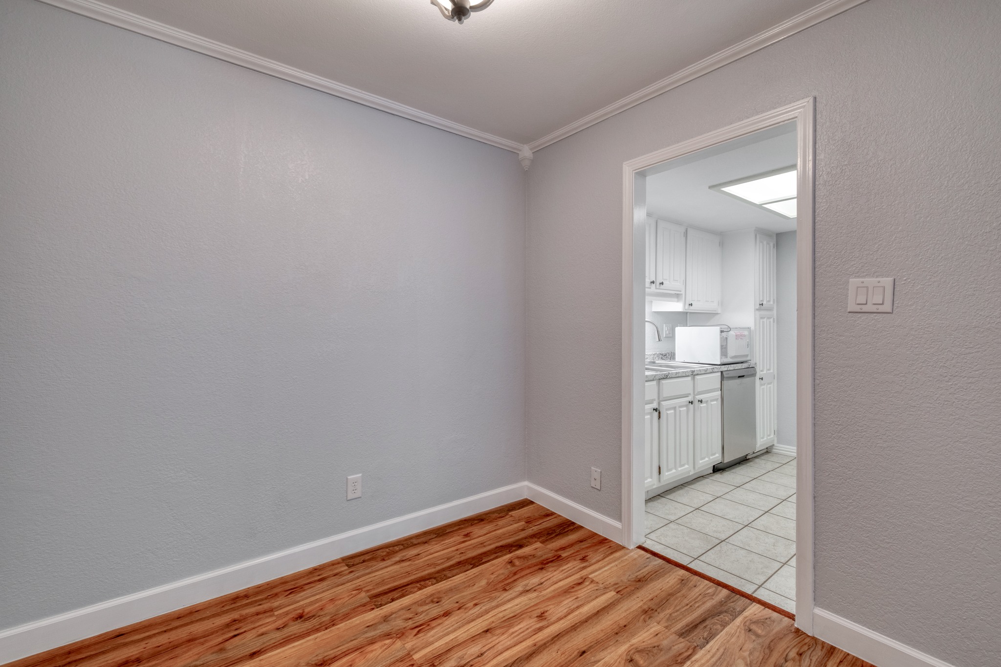 8210 Bent Tree Road, Unit 153 Austin, TX 78759 - Photo 10 of 20 Room featuring wood-finish flooring, light gray walls, and white crown molding