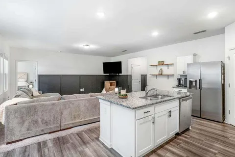 a kitchen with stainless steel appliances granite countertop a sink stove and refrigerator