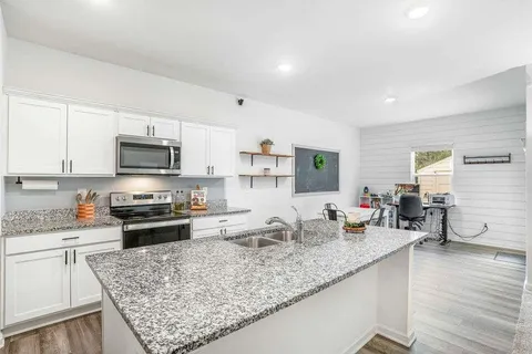 a kitchen with stainless steel appliances granite countertop a sink stove and wooden cabinets