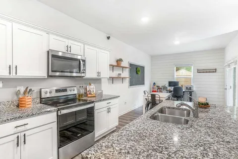 a kitchen that has a sink a stove and cabinets