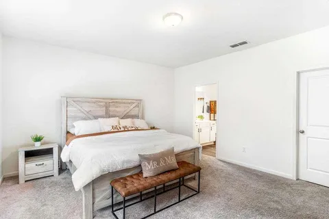 a bedroom with a bed a table and chair