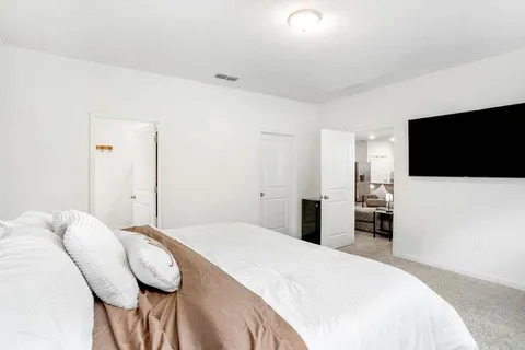 a bedroom with a bed and a flat screen tv