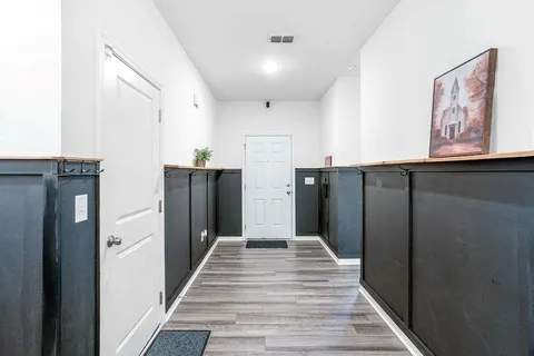 a view of a hallway with wooden floor