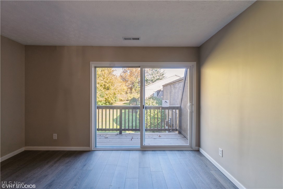 3725 Mayfield Road Cleveland Heights, OH 44121 - Photo 16 of 16 Spare room featuring wood-type flooring and a textured ceiling