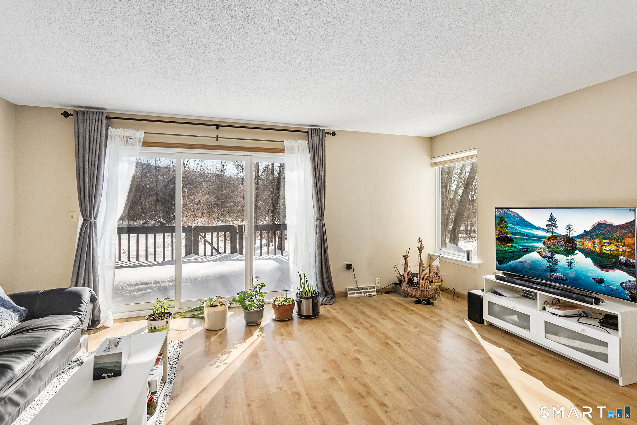 126 Hopmeadow Street, Unit 3H Simsbury, CT 06089 - Photo 1 of 1 a living room with furniture and a flat screen tv