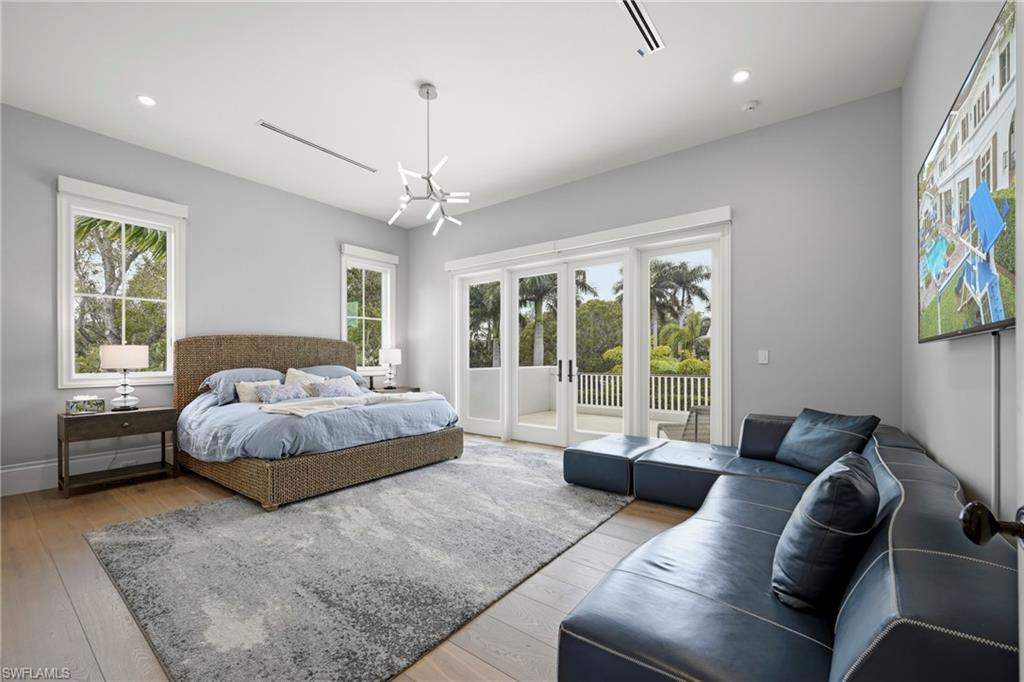 215 3rd Avenue North Naples, FL 34102 - Photo 34 of 47 Bedroom featuring light wood-type flooring, access to exterior, and suspended lighting