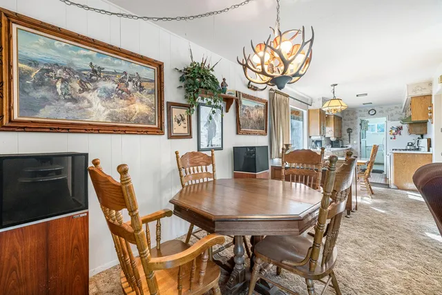 a view of a dining room with furniture a chandelier and wooden floor