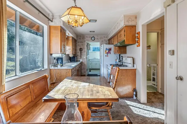 a large kitchen with stainless steel appliances granite countertop a refrigerator and a view of living room