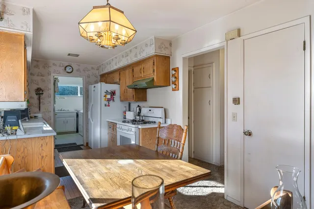 a kitchen with stainless steel appliances granite countertop a stove a refrigerator and a dining table