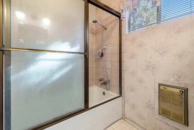a bathroom with a glass shower door and a bathtub