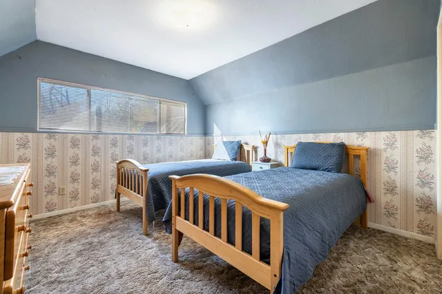 a bedroom with bed and wooden floor