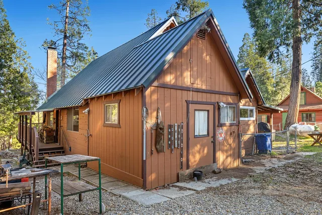 a backyard of a house with barbeque oven table and chairs