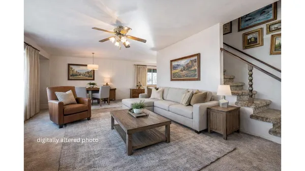a living room with furniture and a ceiling fan
