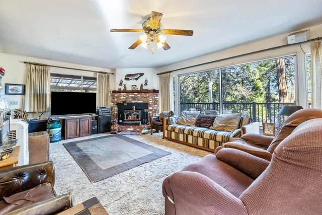 a living room with furniture a flat screen tv and a large window
