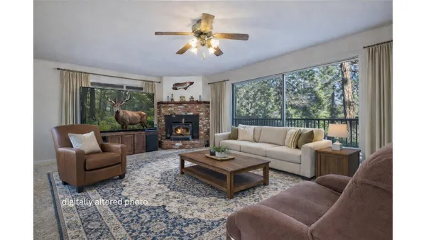 a living room with furniture a fireplace and a large window