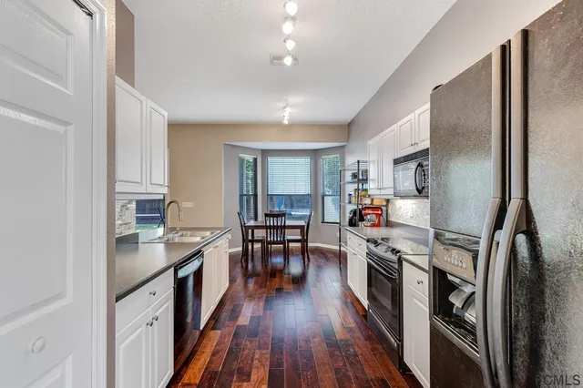 a kitchen with kitchen island a counter top space a sink stainless steel appliances and cabinets