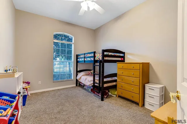 a bedroom with bunk bed and a window