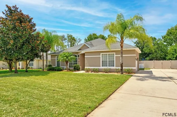 a front view of a house with a garden and yard