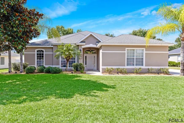 an aerial view of a house with a yard and trees