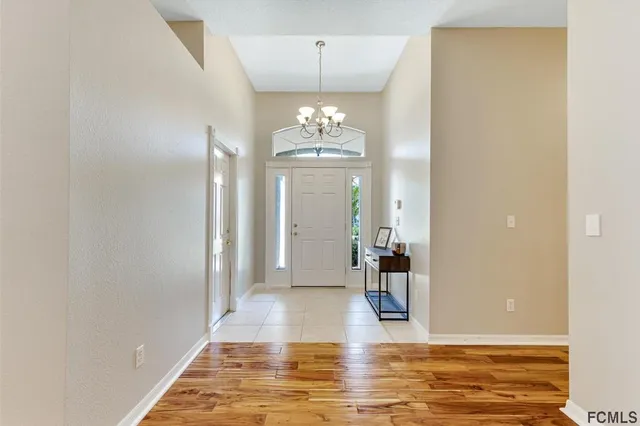 a view of a hallway with wooden floor and a chandelier