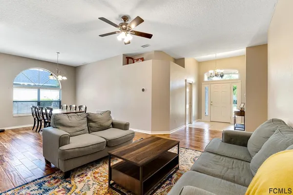 a living room with furniture and a chandelier