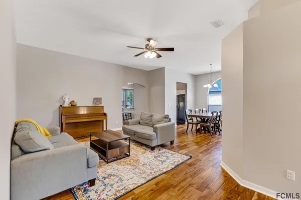 a living room with furniture ceiling fan and a rug