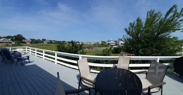 a balcony with wooden floor and outdoor seating