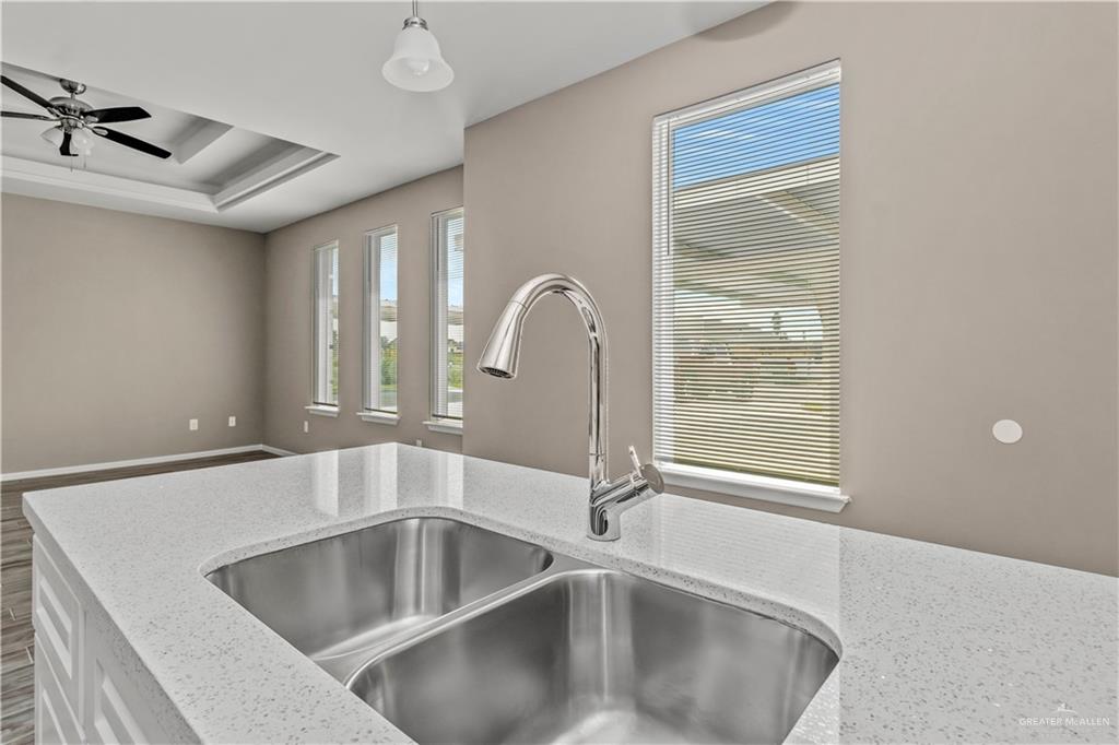 1314 Beverly Avenue, Unit 3 Weslaco, TX 78596 - Photo 5 of 11 Kitchen with light stone countertops, sink, a tray ceiling, and ceiling fan