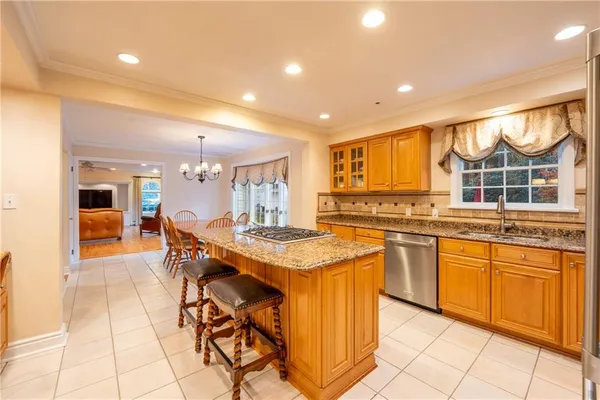 a kitchen with stainless steel appliances granite countertop table chairs sink and cabinets